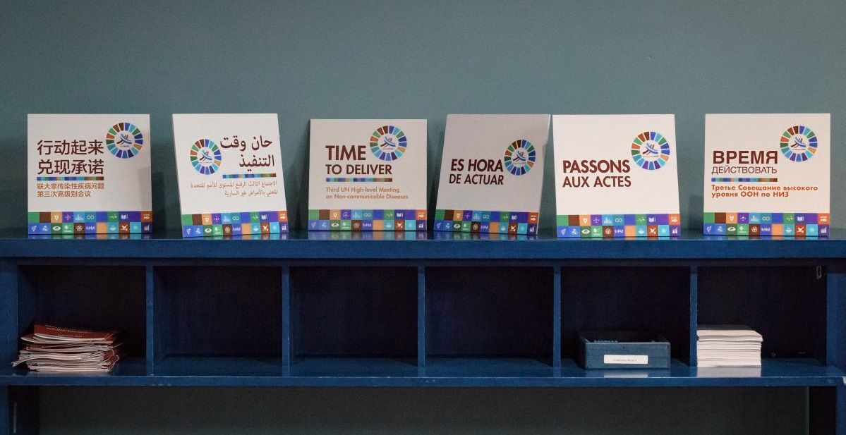 UN Photo by Manuel Elias, Signs reading "Time to Deliver" in the six official languages of the United Nations, on display during the high-level meeting on non-communicable diseases